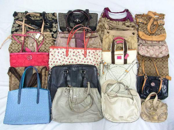 A variety of Coach canvas and leather handbags and totes arranged on a white background as a lot.
