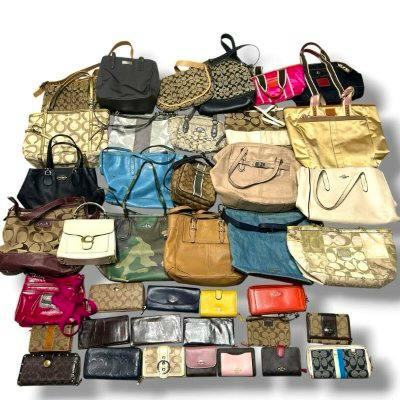 Overhead photo of an assortment of COACH tote bags, shoulder bags, and wallets arranged on a white background.