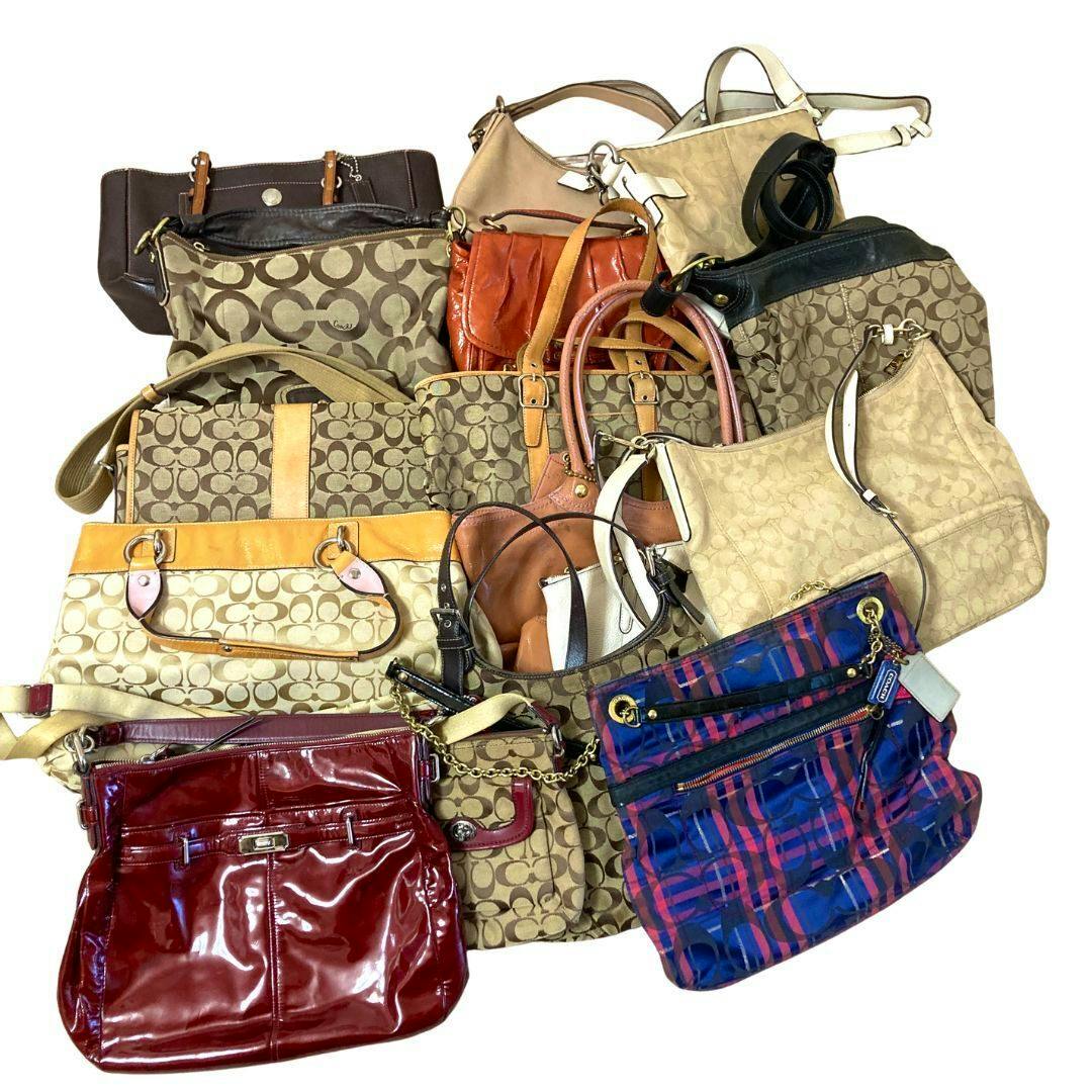Pile of multiple Coach bags in assorted colors and signature patterns displayed on a white background.