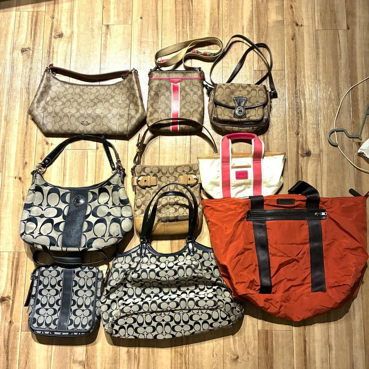 Nine Coach bags in various styles arranged on a wooden floor, shown together as a set.