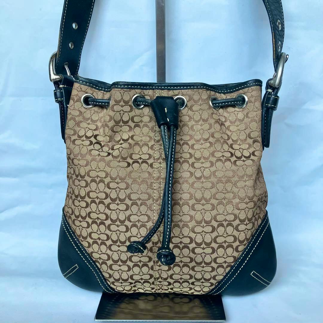 Front view of the COACH signature canvas drawstring (巾着) shoulder bag with leather trim.
