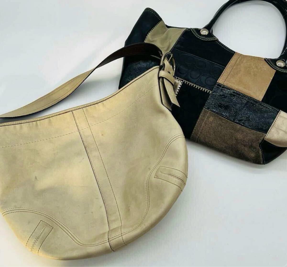 Two COACH bags: a beige leather shoulder bag and a black-and-tan patchwork handbag on a white background.