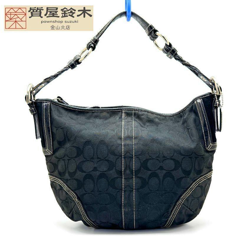 Front view of the black COACH signature canvas one-shoulder handbag showing the C logo pattern and braided shoulder strap.