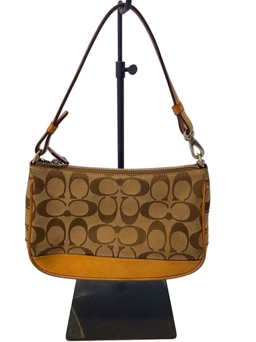Coach signature canvas pouch with C-pattern and tan leather trim hanging on a display stand.