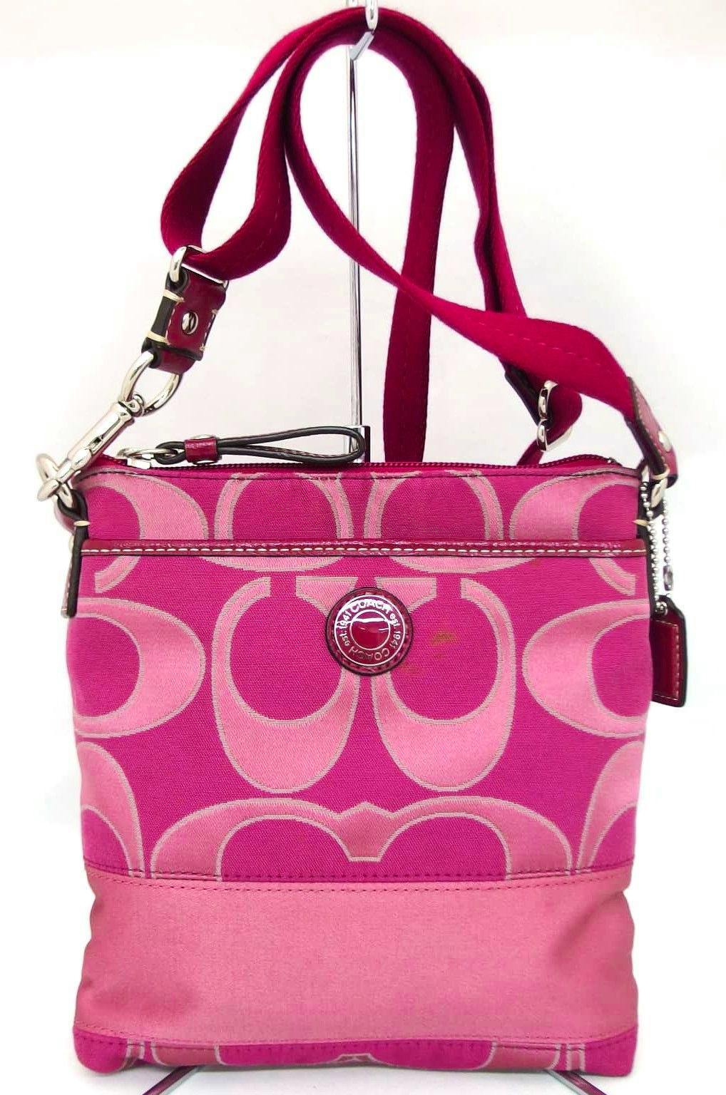 Front view of a pink Coach signature canvas shoulder bag with strap and round logo plaque.