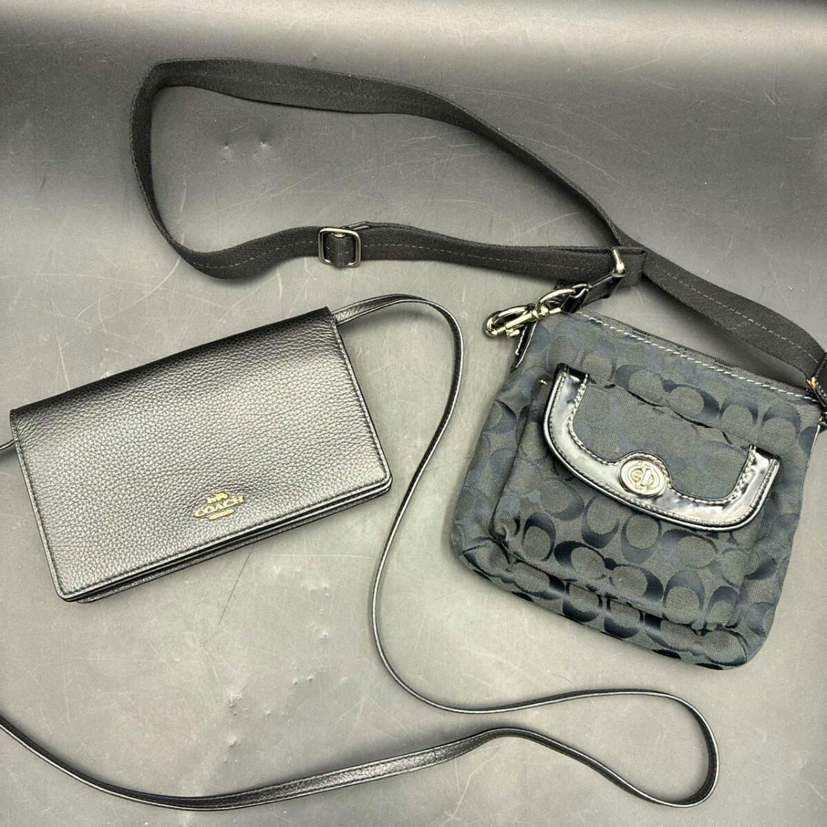 Two black Coach items laid flat: a pebbled leather shoulder wallet and a signature canvas shoulder bag with straps.