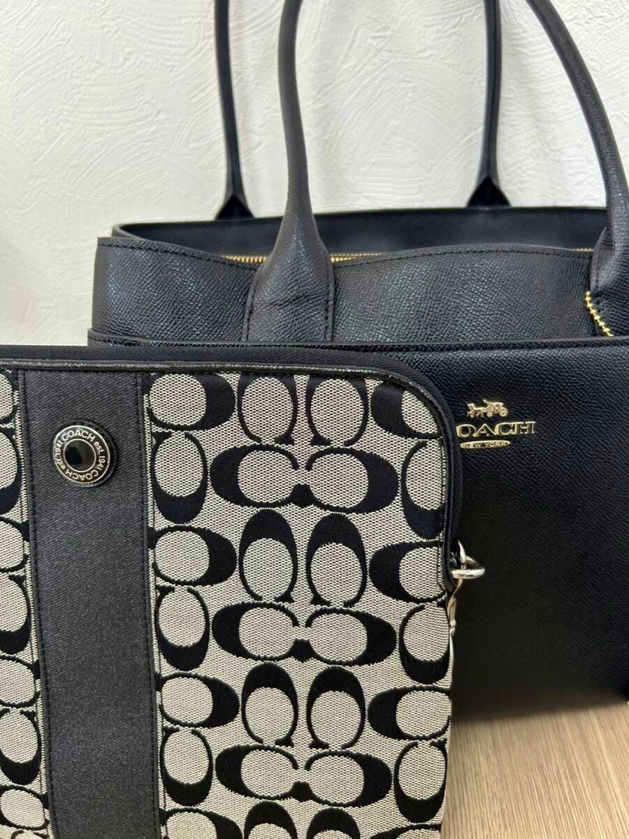 Black COACH tote bag with gold logo and matching black-and-white signature clutch shown together.