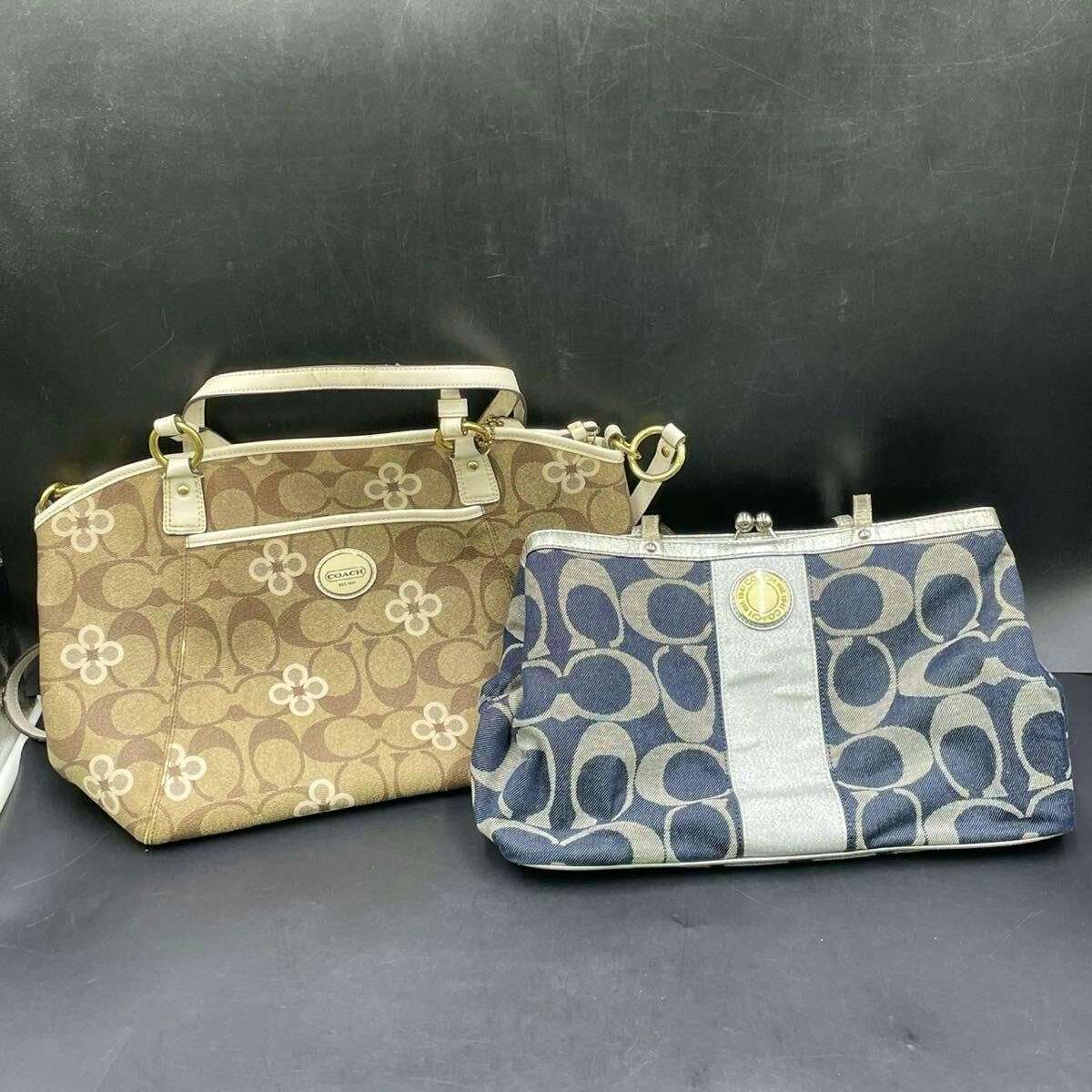Two COACH canvas tote bags with signature C pattern, one brown and one blue, displayed on a black background.