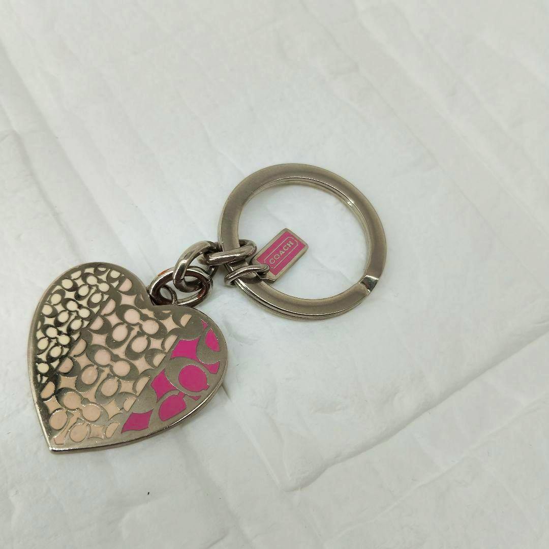 Heart-shaped COACH keychain with pink signature accents and metal ring on a white background.