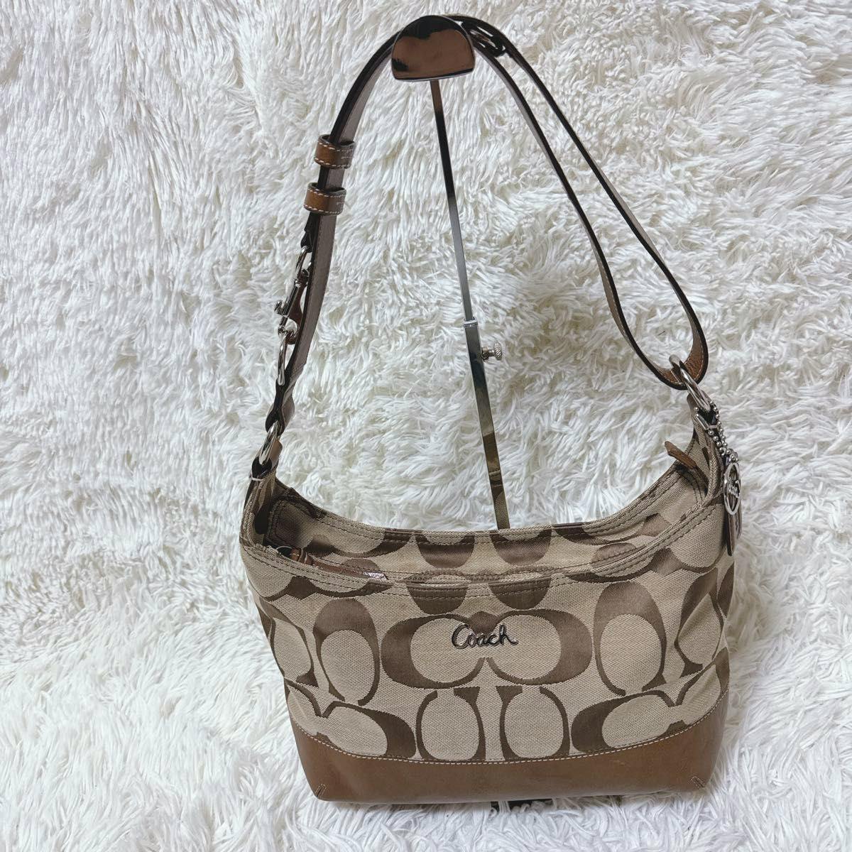 Front view of the COACH signature canvas hobo shoulder bag with brown leather trim and Coach logo.