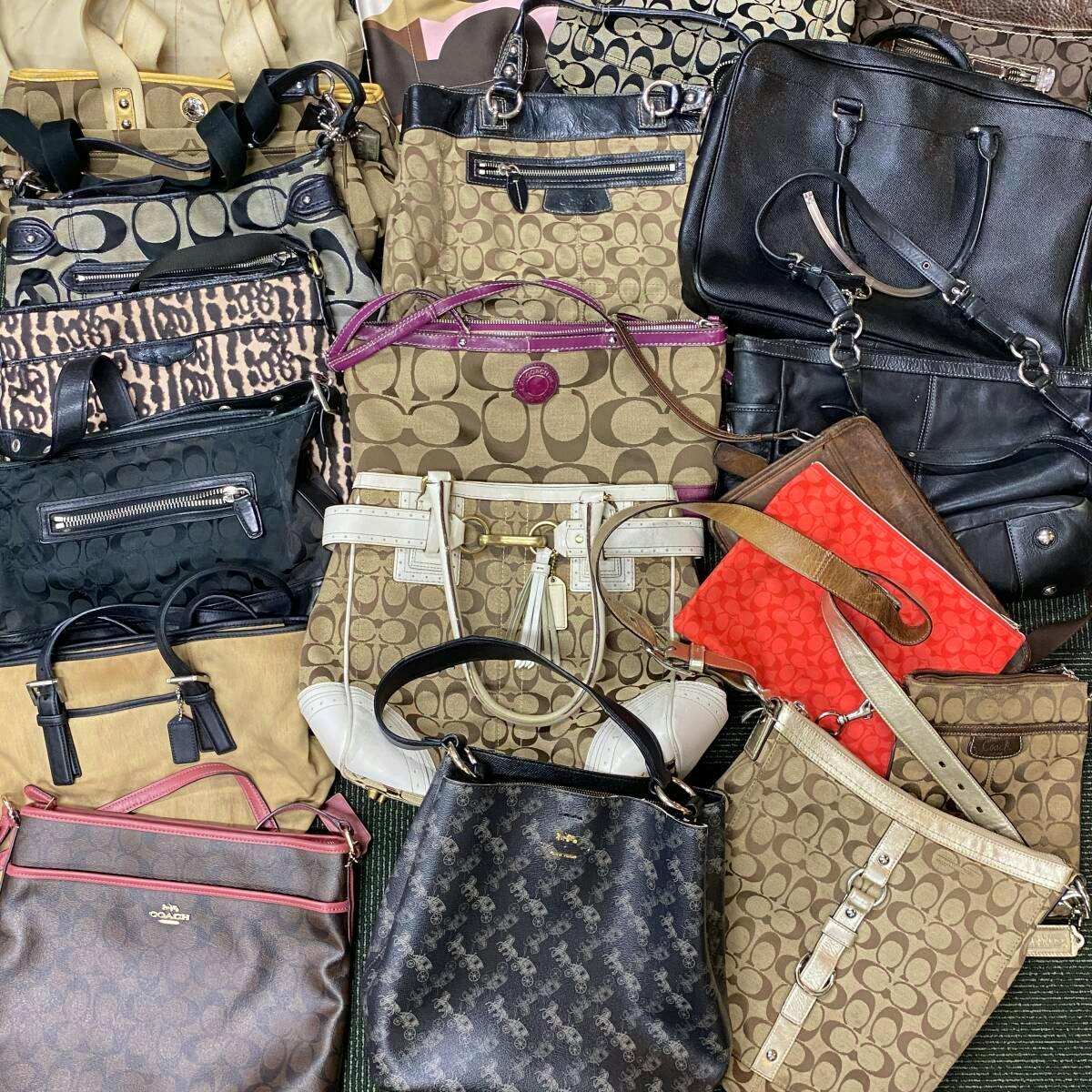 A group of multiple COACH handbags and totes in various signature canvas and leather patterns arranged together.