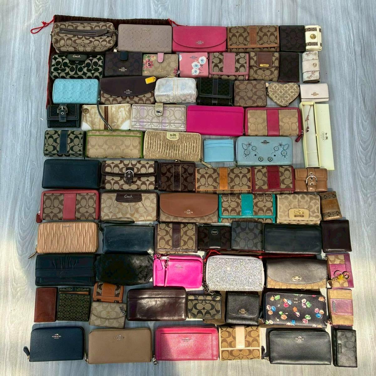Overhead photo of many Coach wallets and small canvas leather goods arranged in rows on the floor as a bulk set.