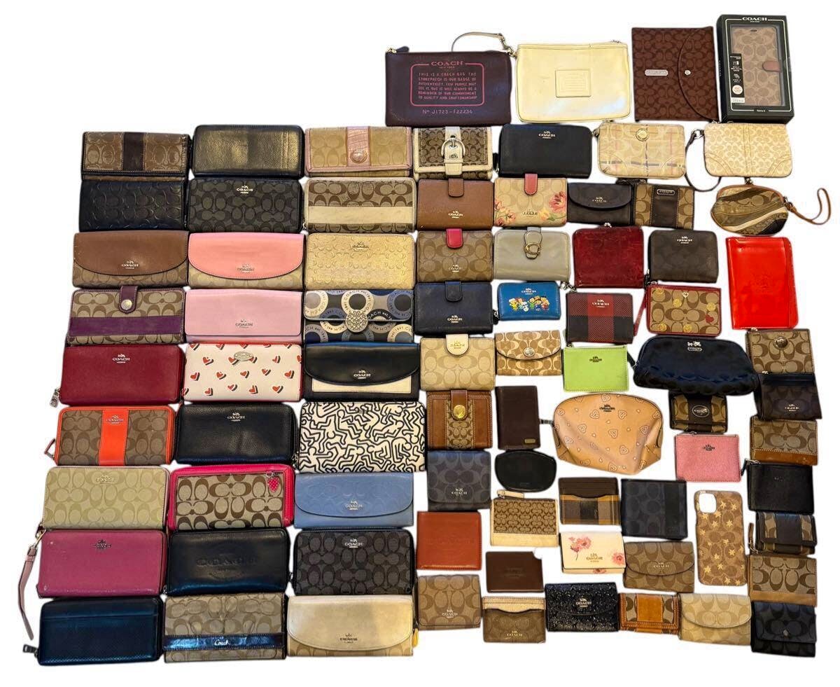 Multiple Coach wallets and small pouches arranged flat in a grid showing various colors, signature patterns, and styles.