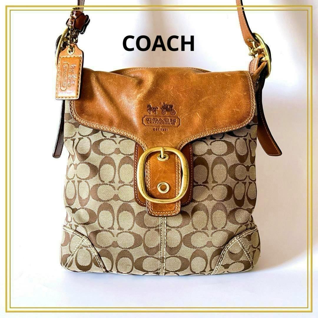 Front view of the Coach signature canvas shoulder bag with brown leather flap, brass buckle, and leather strap.