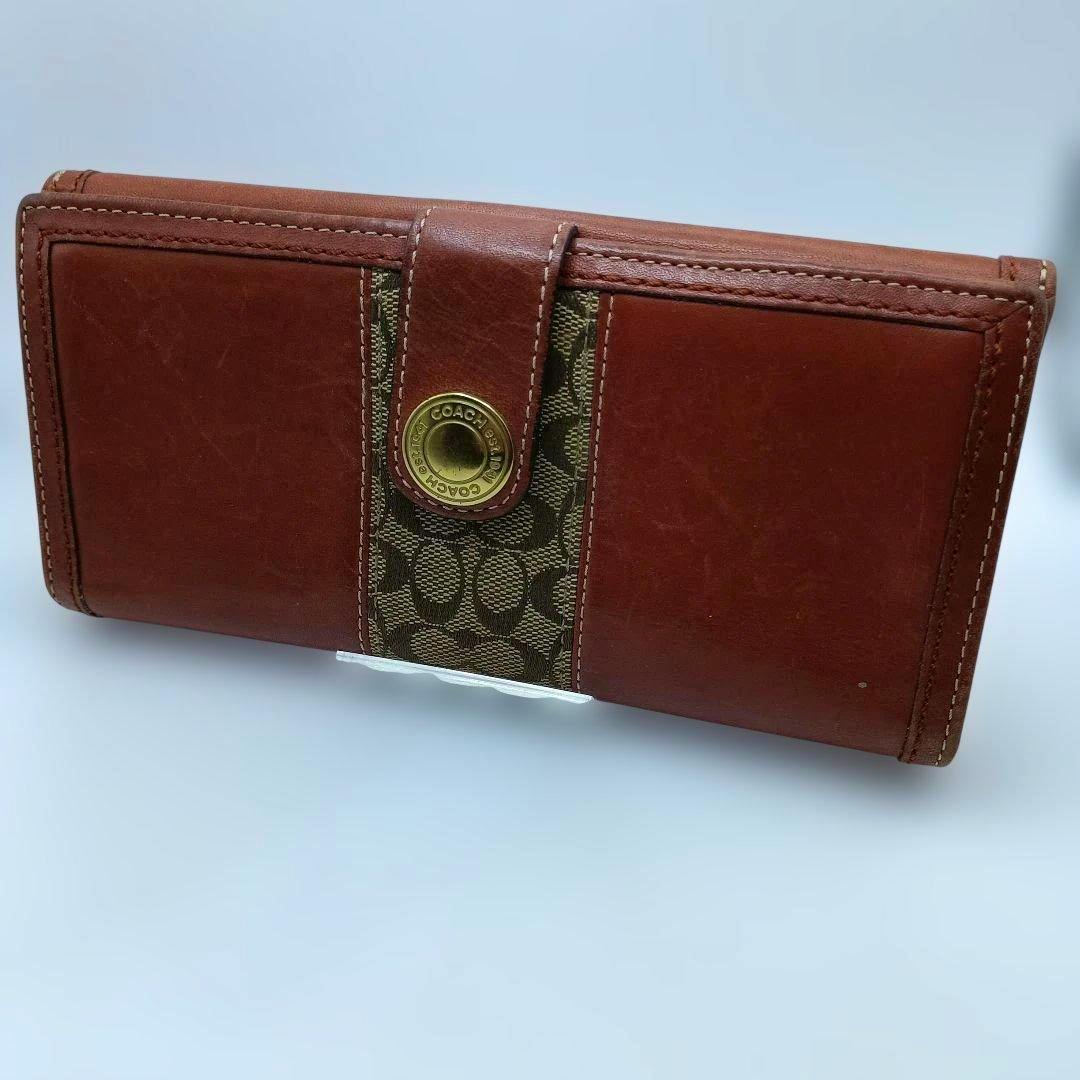 Brown COACH signature long wallet in cow leather with a central signature fabric panel and round metal snap closure.