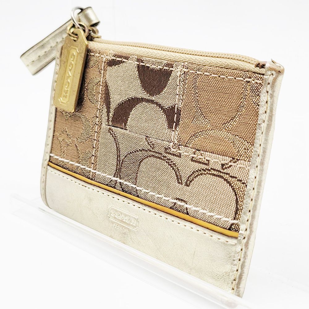 Coach canvas signature patchwork card case with zipper and leather-trimmed pocket.
