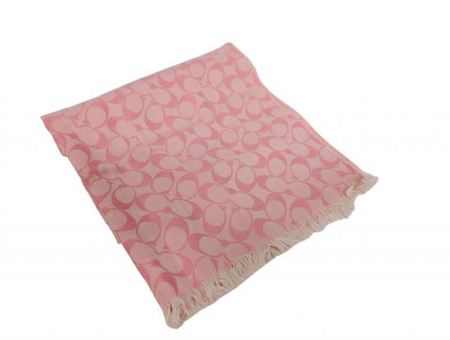 Folded pink COACH signature wool scarf with fringe and repeating 'C' pattern.