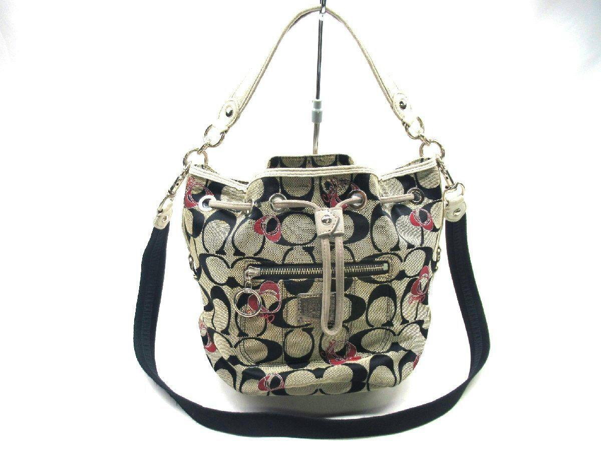 Front view of the COACH signature canvas Poppy drawstring shoulder bag in gray tones with a shoulder strap on a white background.