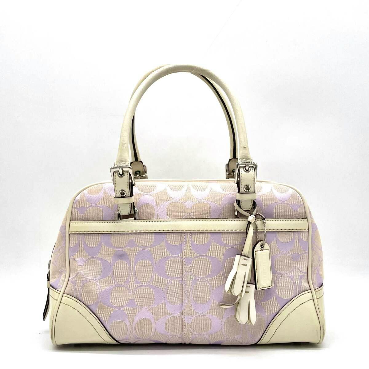 Front view of a purple Coach signature mini Boston handbag with white leather trim, handles, and hanging tassel and tag.