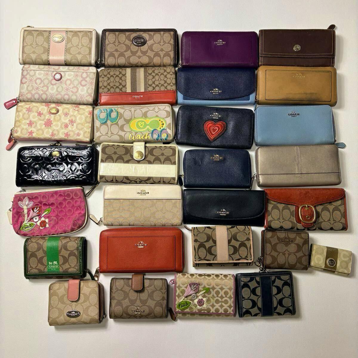 Top-down photo of many COACH wallets and small coin wallets arranged on a white background.
