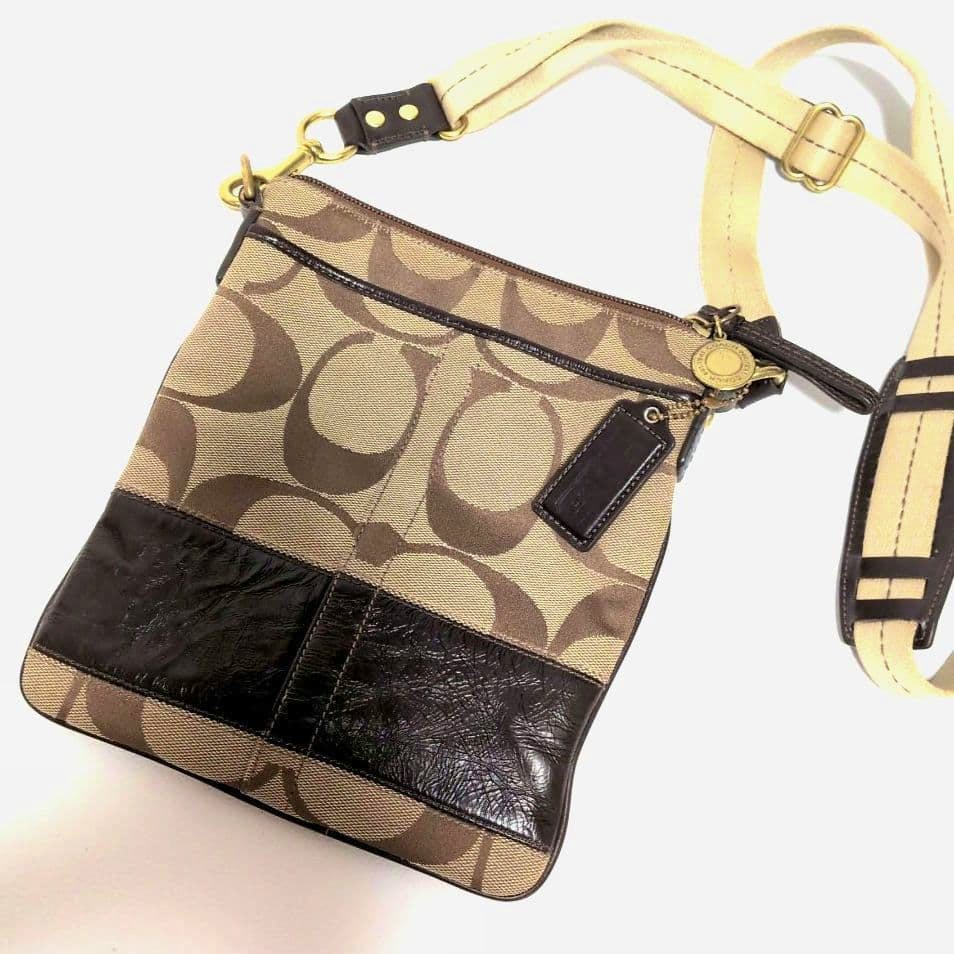 Coach signature canvas sacoche bag with tan and brown 'C' monogram, dark brown leather trim, and an adjustable canvas strap.