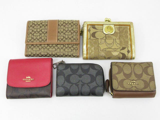 Five COACH signature short wallets and coin cases displayed on a white background.