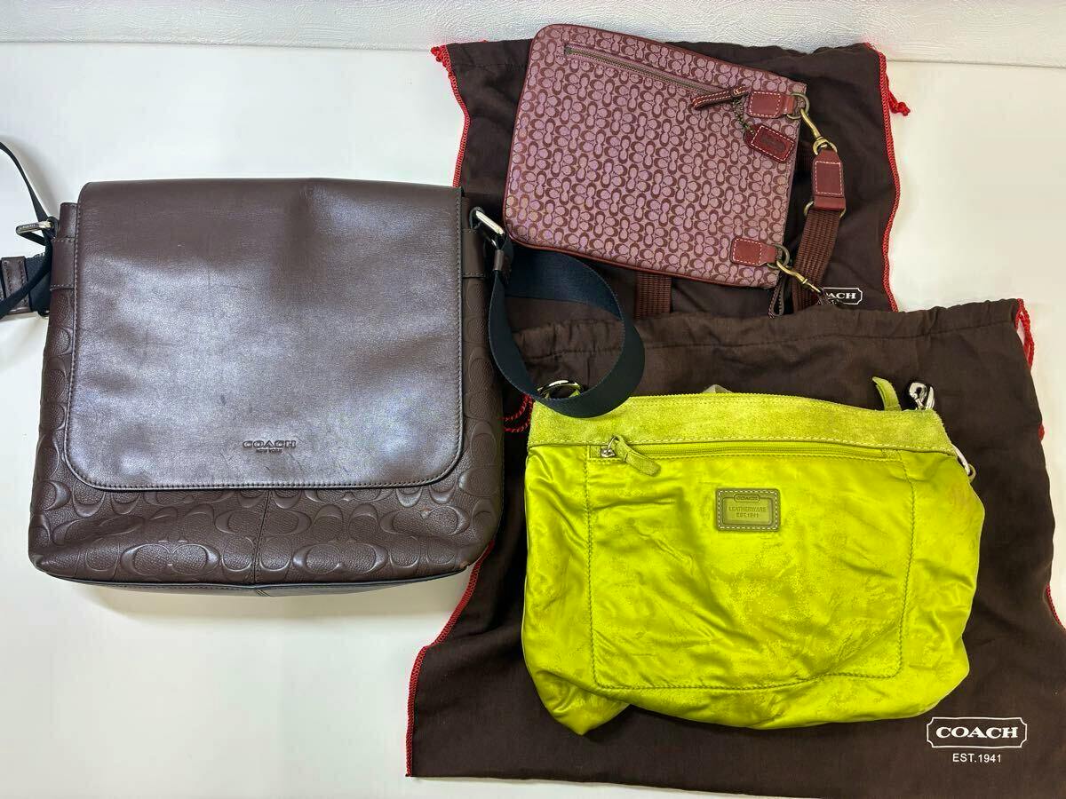 Top-down photo of three Coach bags—a brown shoulder bag, a pink signature-pattern crossbody, and a lime-green small bag—laid on Coach dust bags.