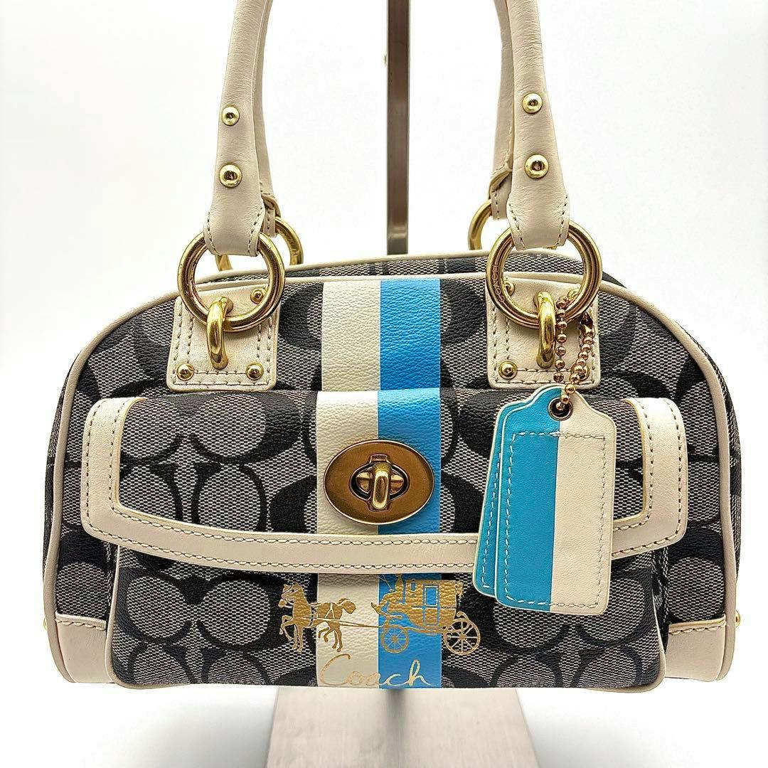 Front view of the COACH Signature Stripe satchel bag in signature canvas with a center blue and white stripe, front turn-lock pocket, leather tag, and gold hardware.