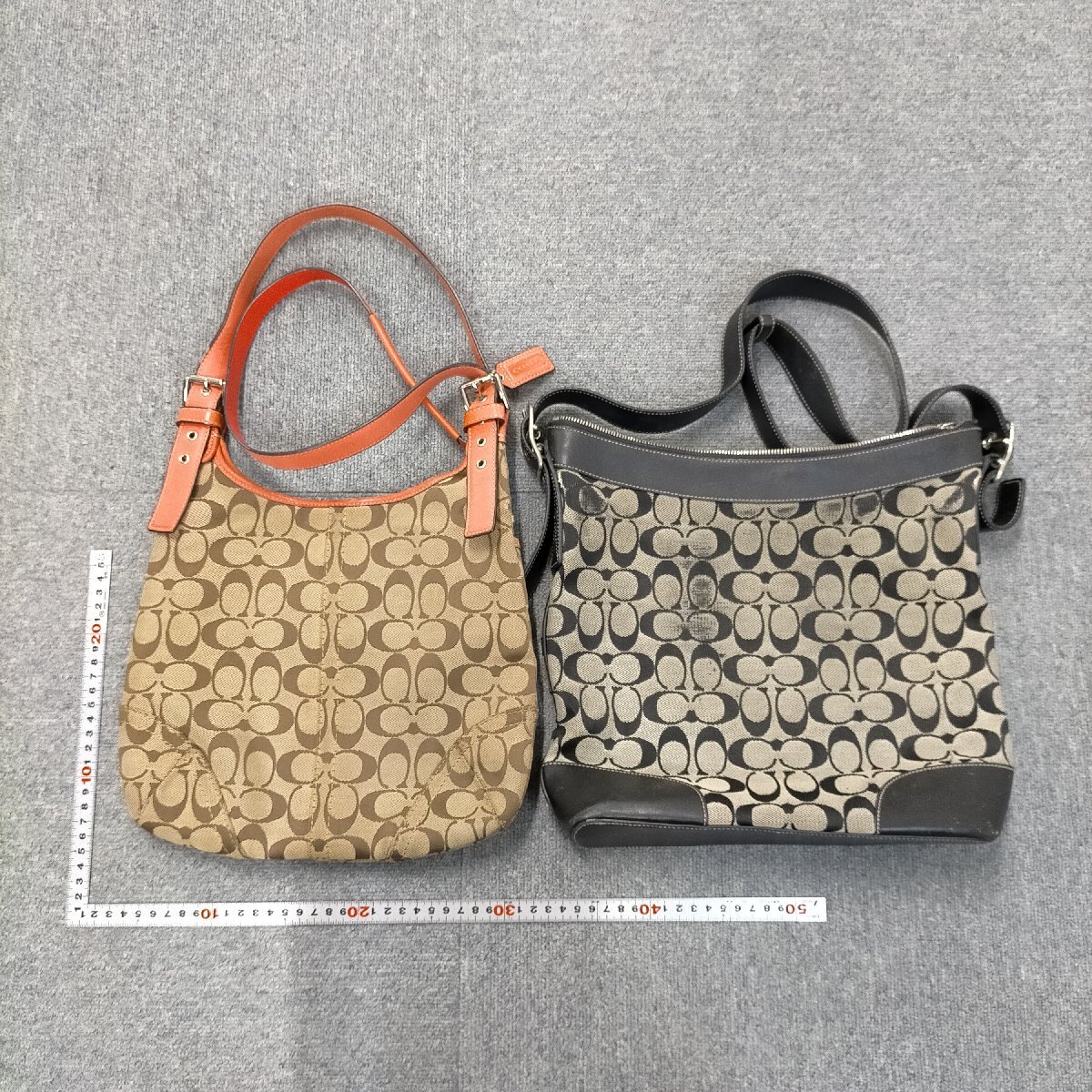 Two Coach signature bags, one brown and one black, shown side by side on a gray background with measuring rulers.