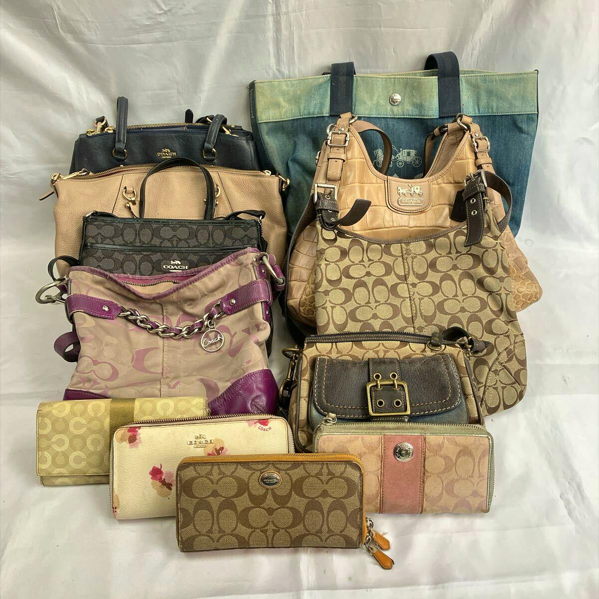 A collection of Coach handbags, totes and wallets arranged on a white background showing signature canvas and leather styles.