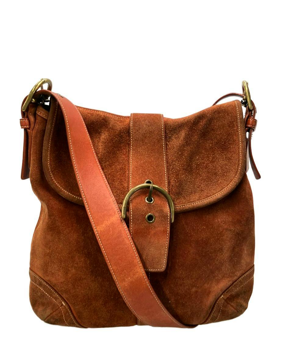 COACH brown suede one-shoulder crossbody bag with a front flap and round brass buckle.