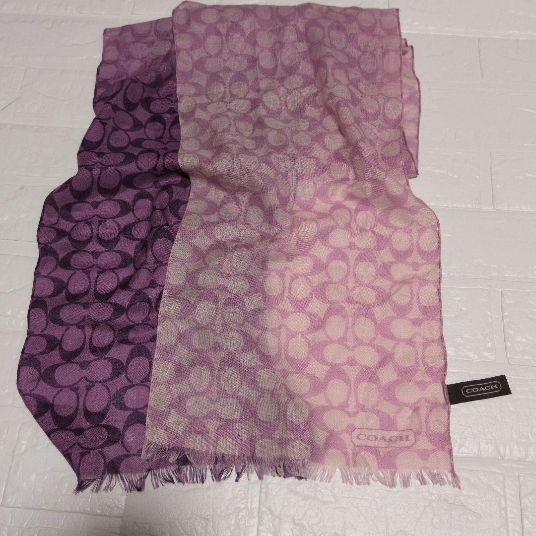 Purple gradient COACH signature wool scarf laid flat showing the pattern, fringe, and logo tag.