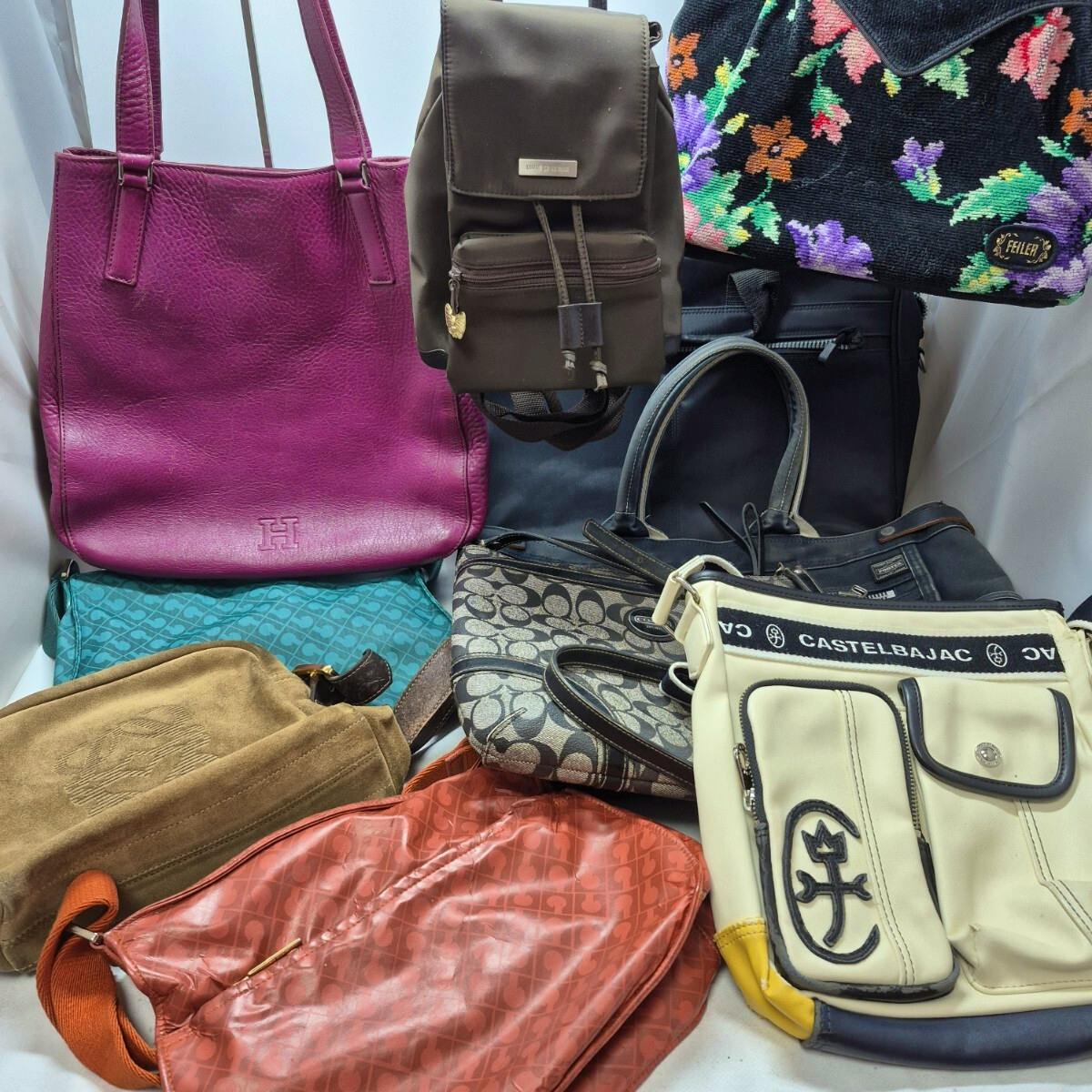 Multiple handbags and shoulder bags arranged together showing various colors and patterns, including a Coach signature canvas bag.
