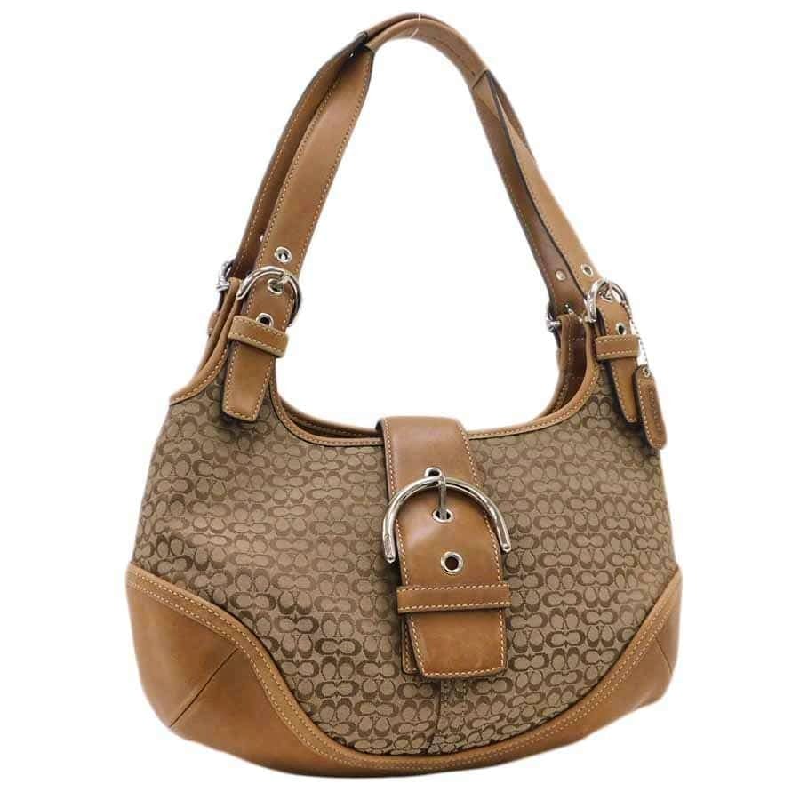 Front view of the brown Coach canvas and leather tote bag showing the mini signature pattern and central buckle detail.