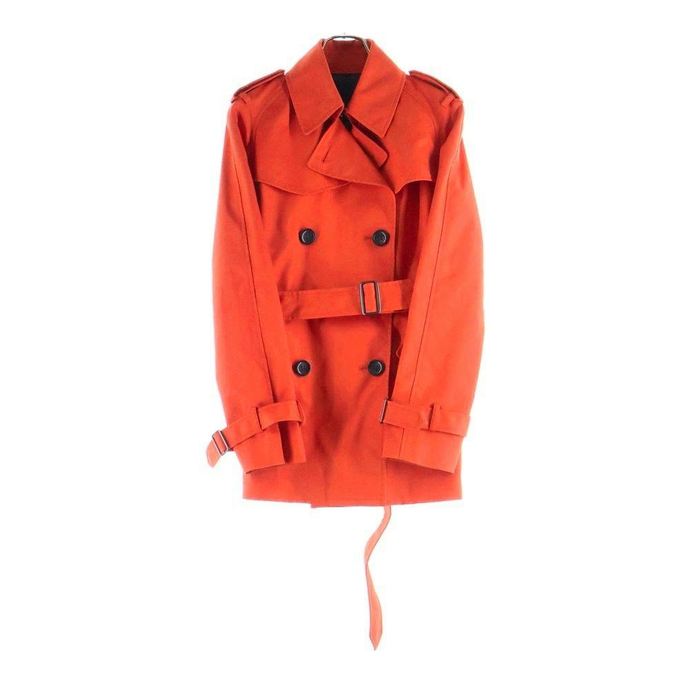 Orange women's short trench coat by COACH displayed on a hanger against a white background.
