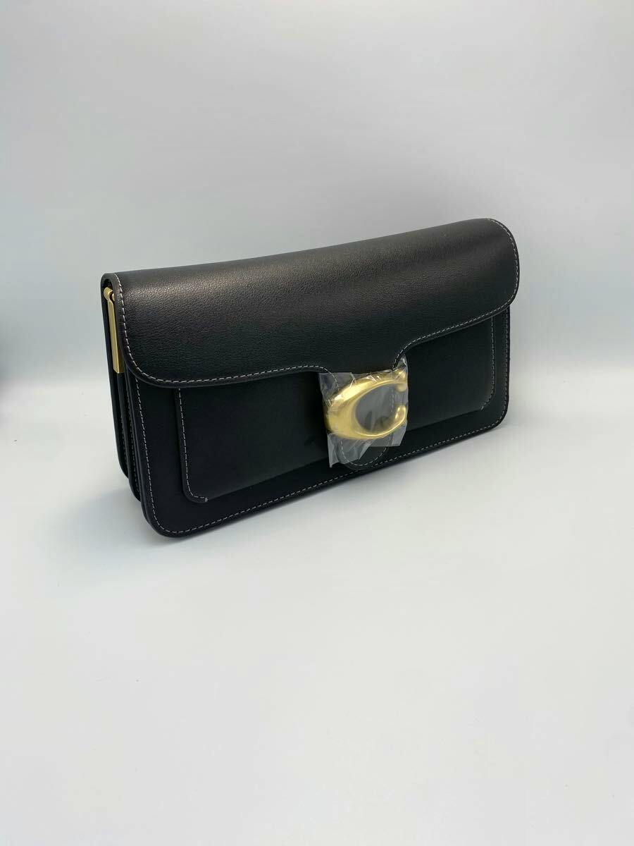Black cow leather Coach Tabby shoulder bag with visible gold clasp photographed on a plain background.