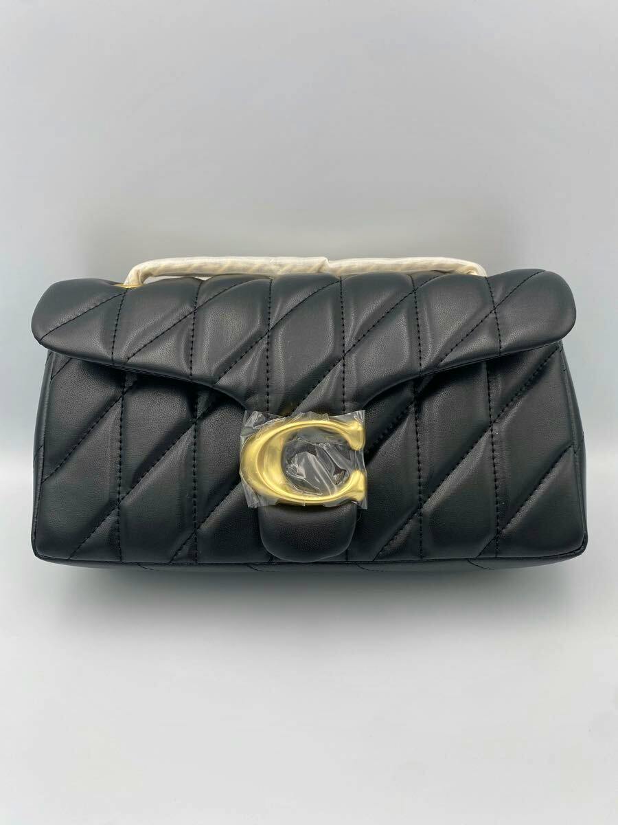 Front view of a black COACH Tabby 26 shoulder bag in quilted leather with diagonal stitching and a gold C clasp.