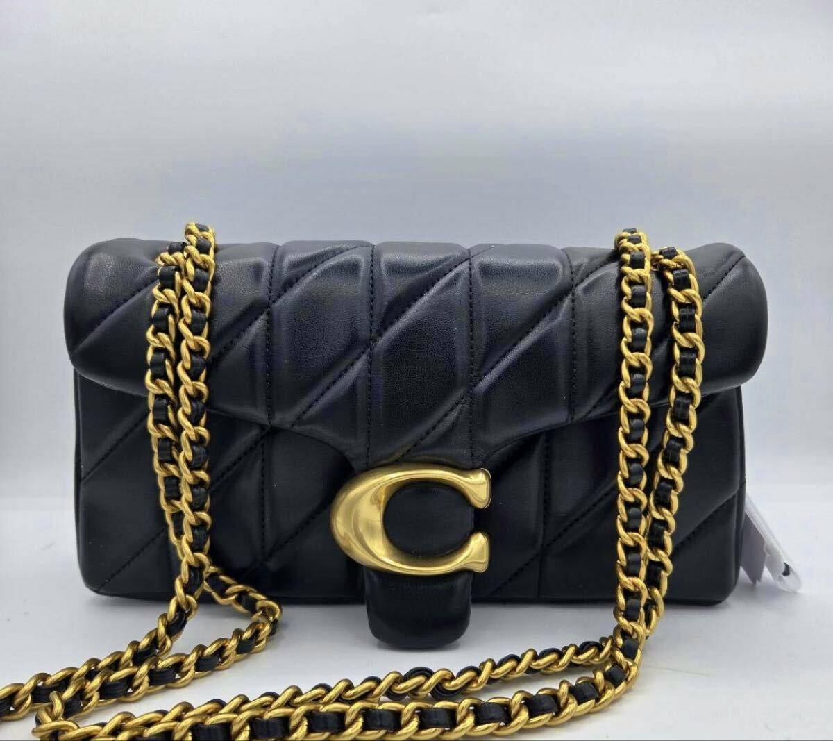 Front view of a black quilted COACH Tabby shoulder bag with a gold C clasp and gold-and-black chain strap.