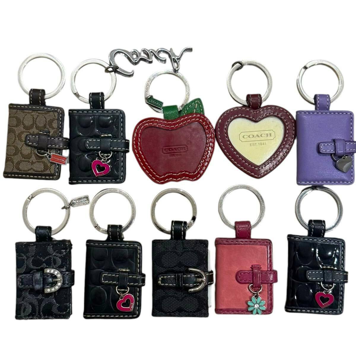Ten COACH keychain tag and notebook-style leather charms arranged on a white background.