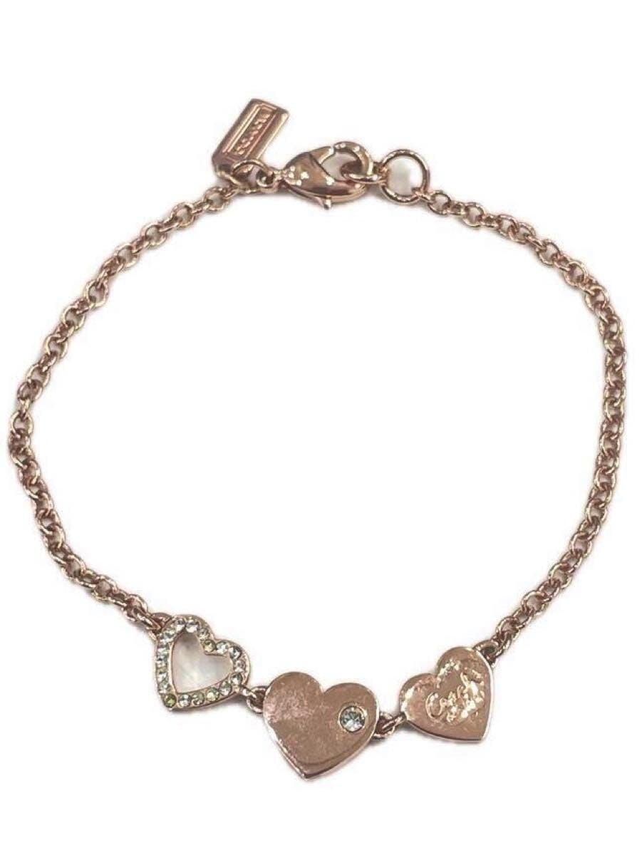 Three-heart COACH bracelet with chain and lobster clasp photographed on a white background.