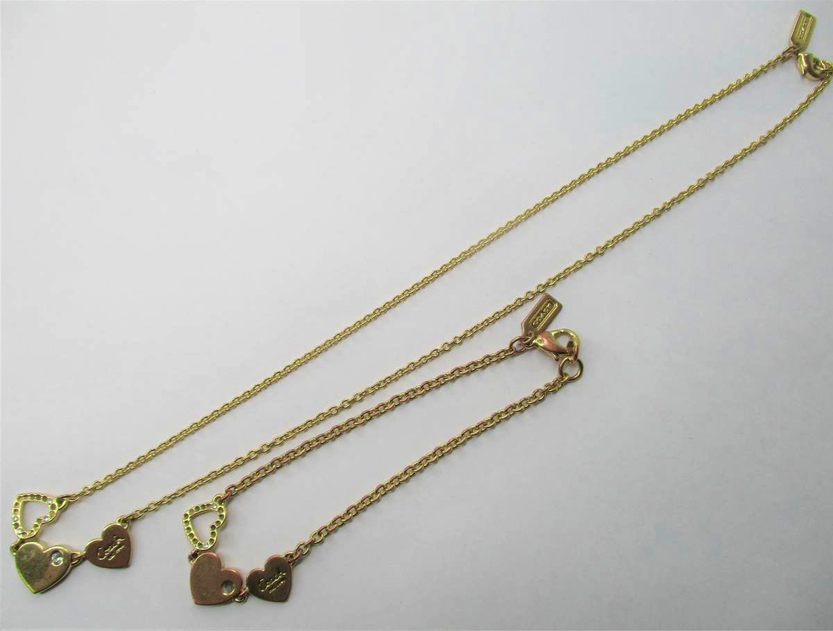 Necklace and bracelet set with three heart charms, COACH tag, and lobster clasp on a white background.