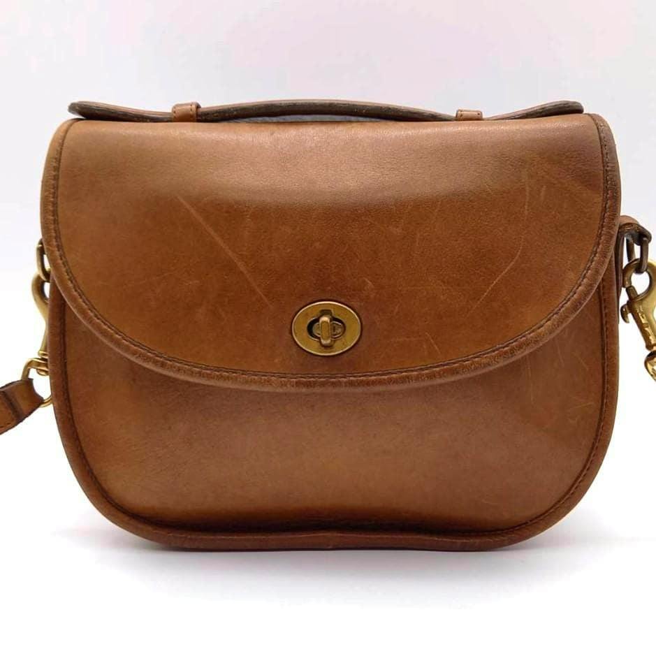 Front view of the COACH vintage brown cow leather 2way turnlock bag showing the turnlock closure and shoulder strap.