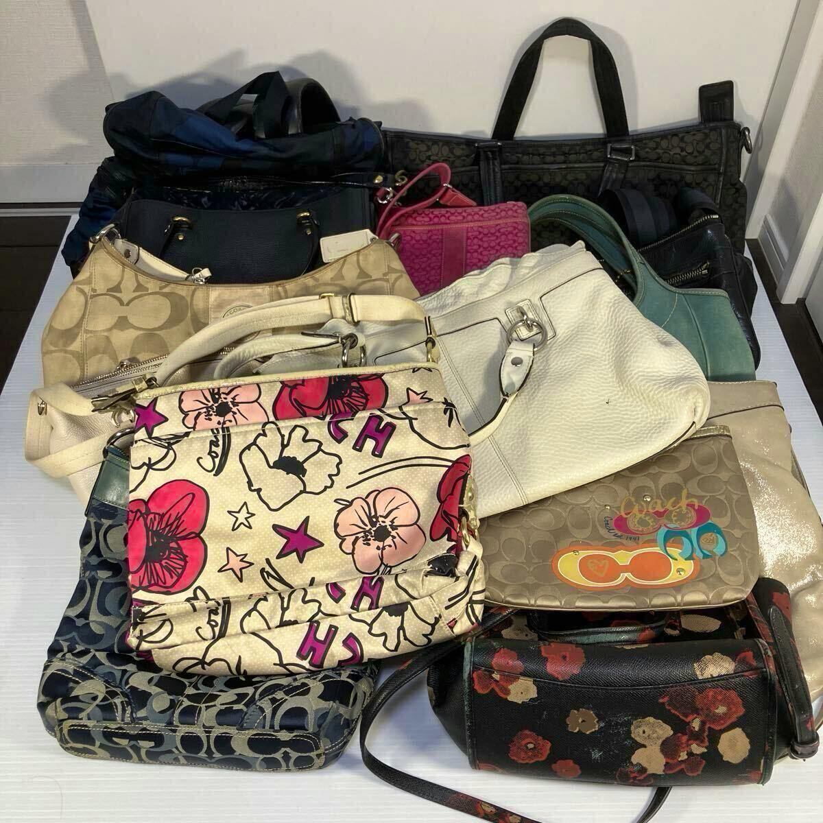 A pile of assorted Coach bags and purses stacked on a white surface, showing various colors and patterns.