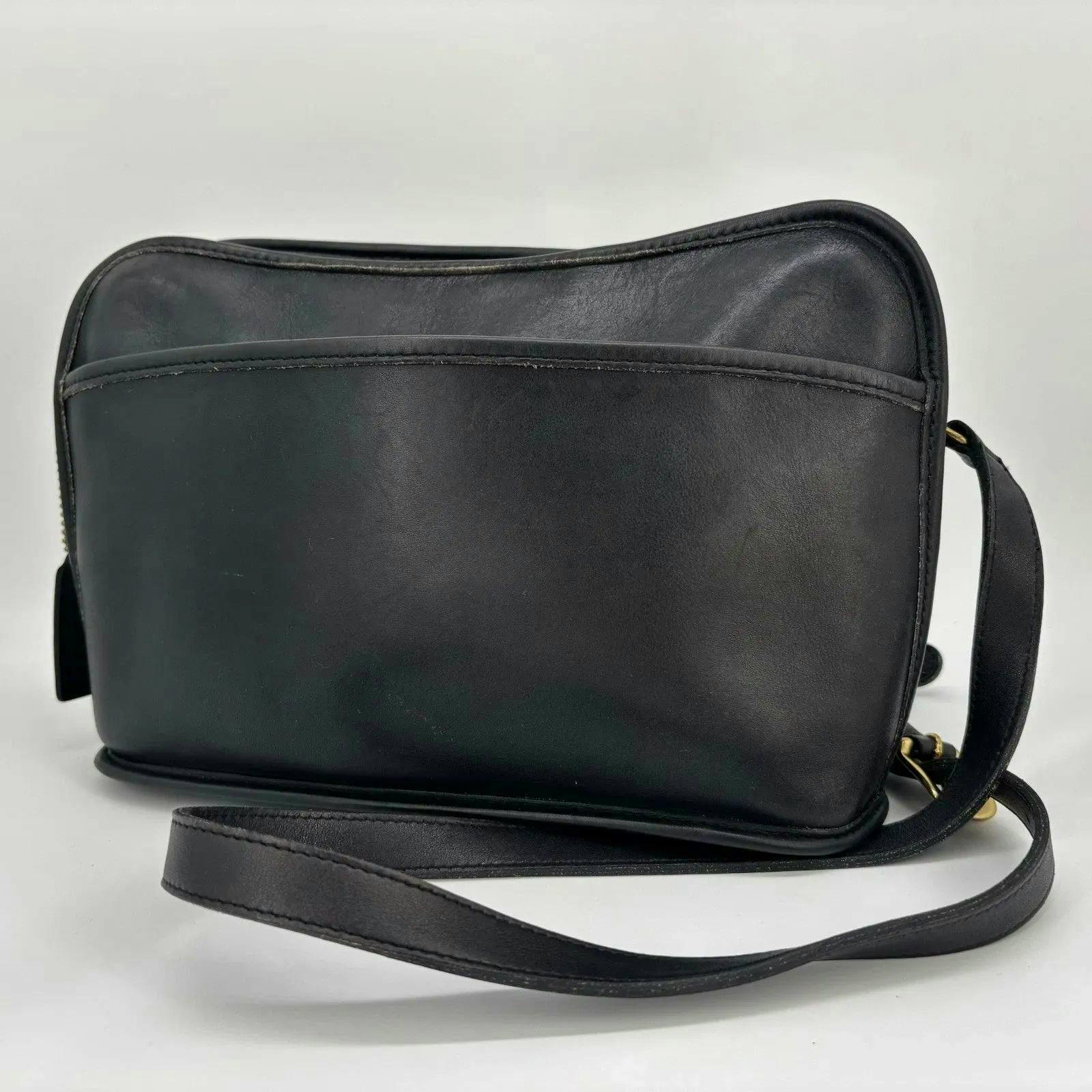 Front view of a black leather Coach shoulder/crossbody bag showing the bag body and strap.