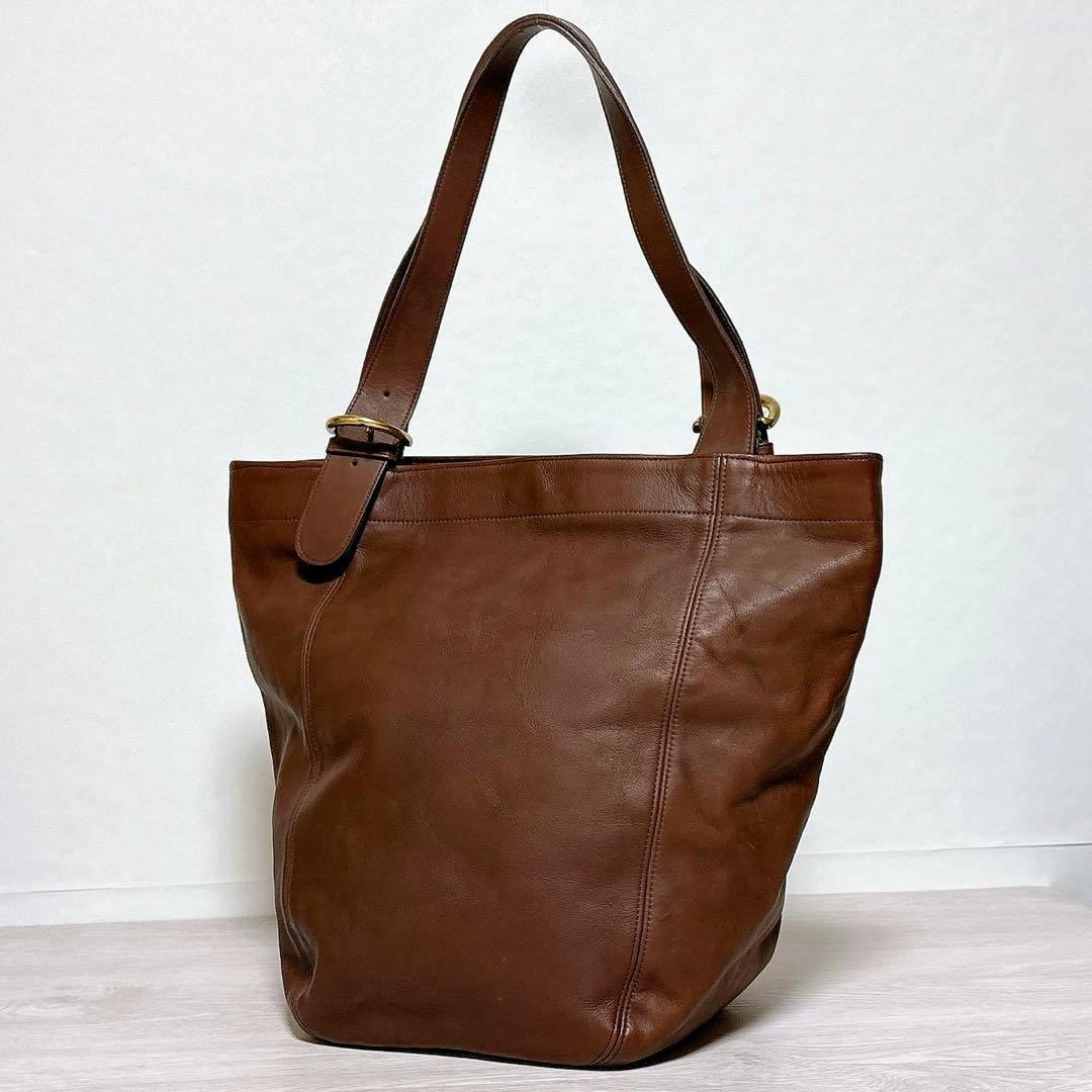 Dark brown leather Coach vintage tote bag with shoulder straps photographed against a plain white background.