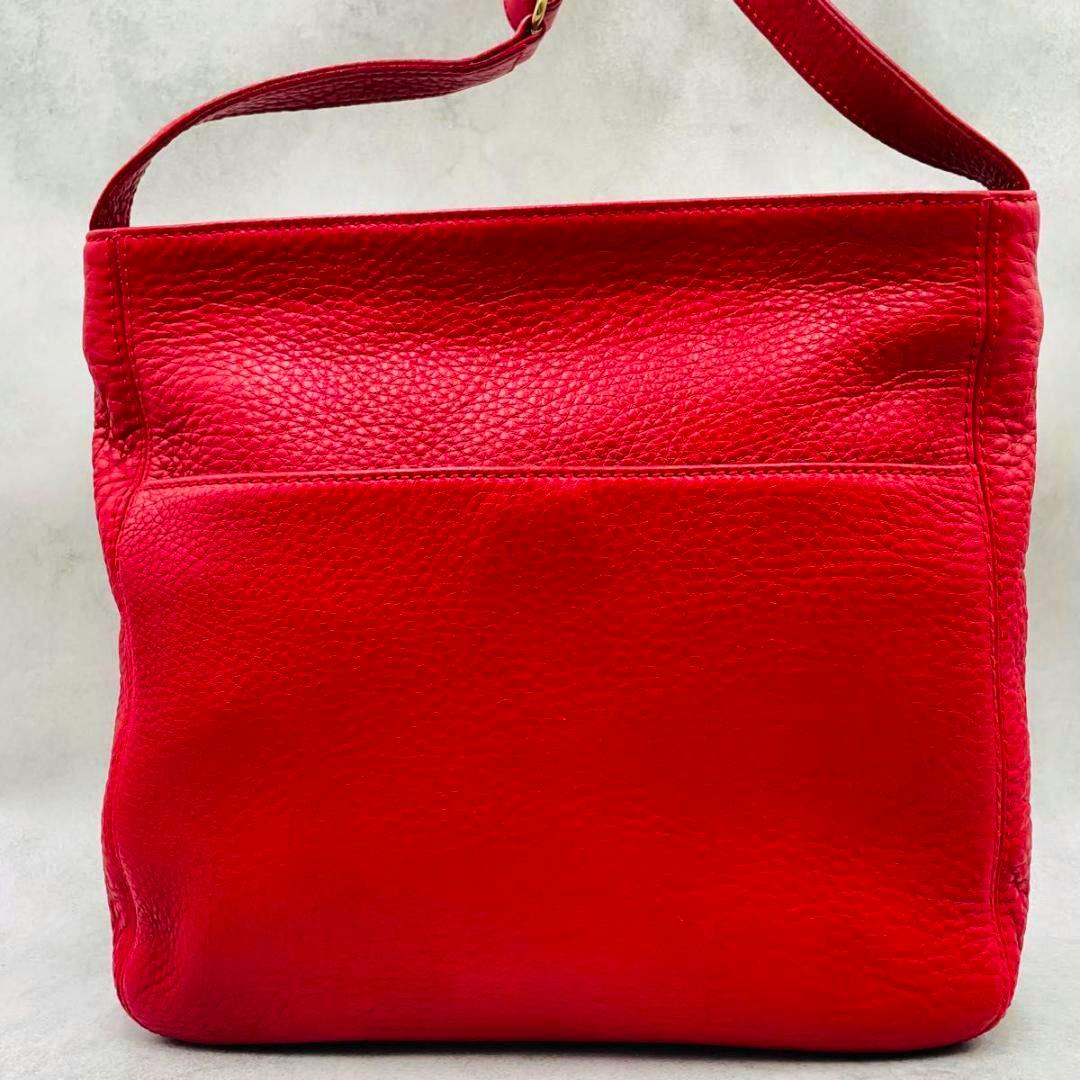 Front view of a red leather Coach one-shoulder bag displayed against a neutral background.