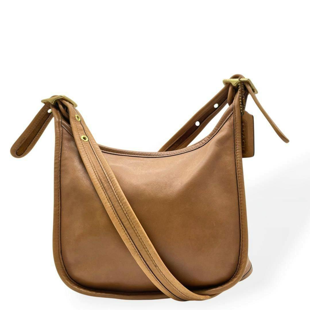 Front view of a brown Coach leather shoulder bag with a single strap and Coach hangtag.