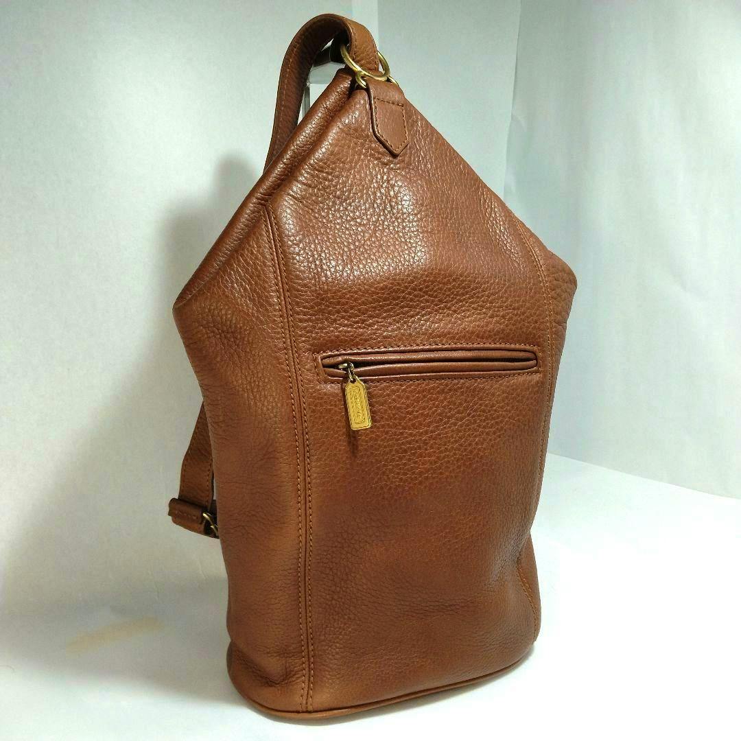 Brown cow leather COACH one-shoulder bag with a front zip pocket and gold-tone zipper pull shown upright.