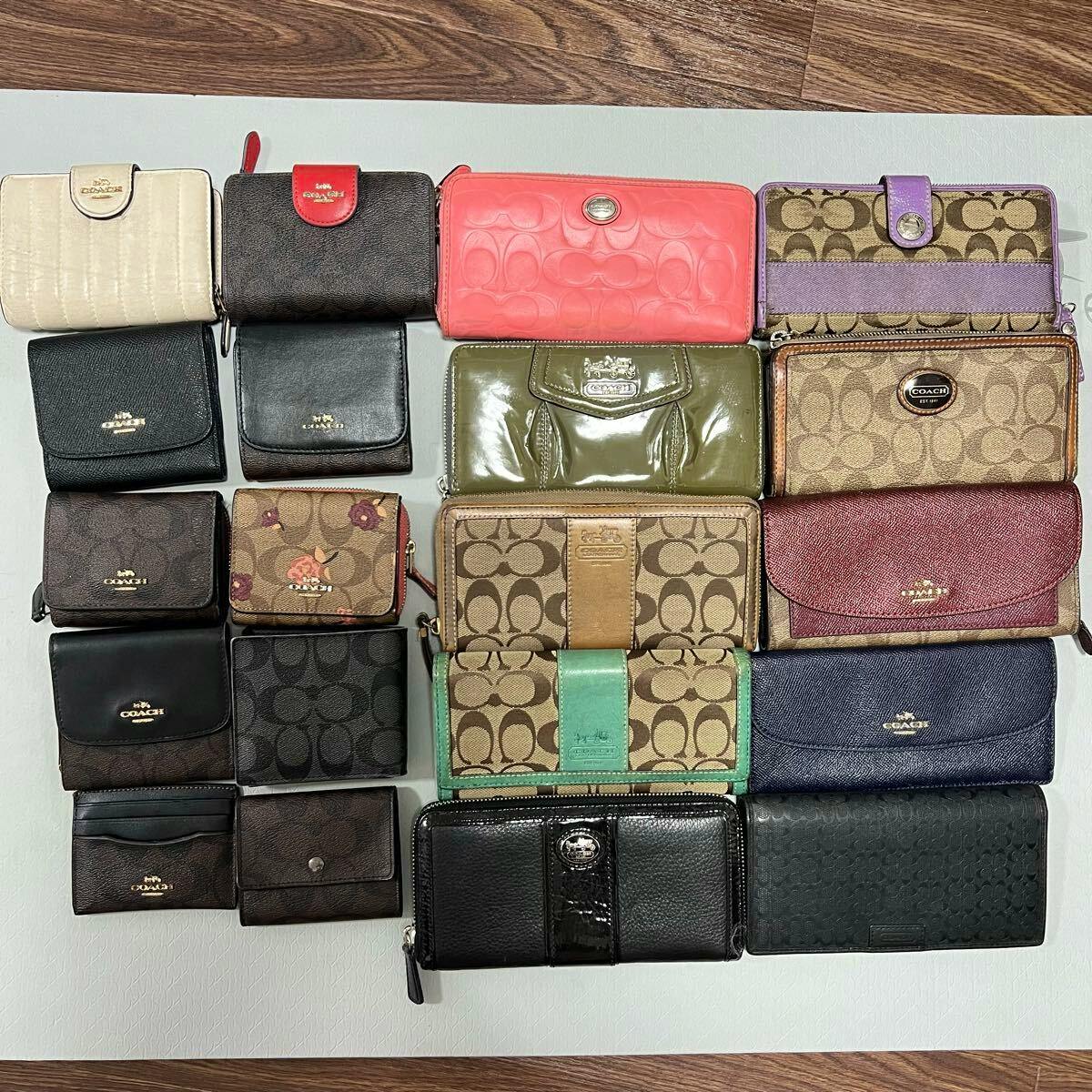 Top-down photo of a set of Coach wallets and small cases arranged in a grid on a flat surface.
