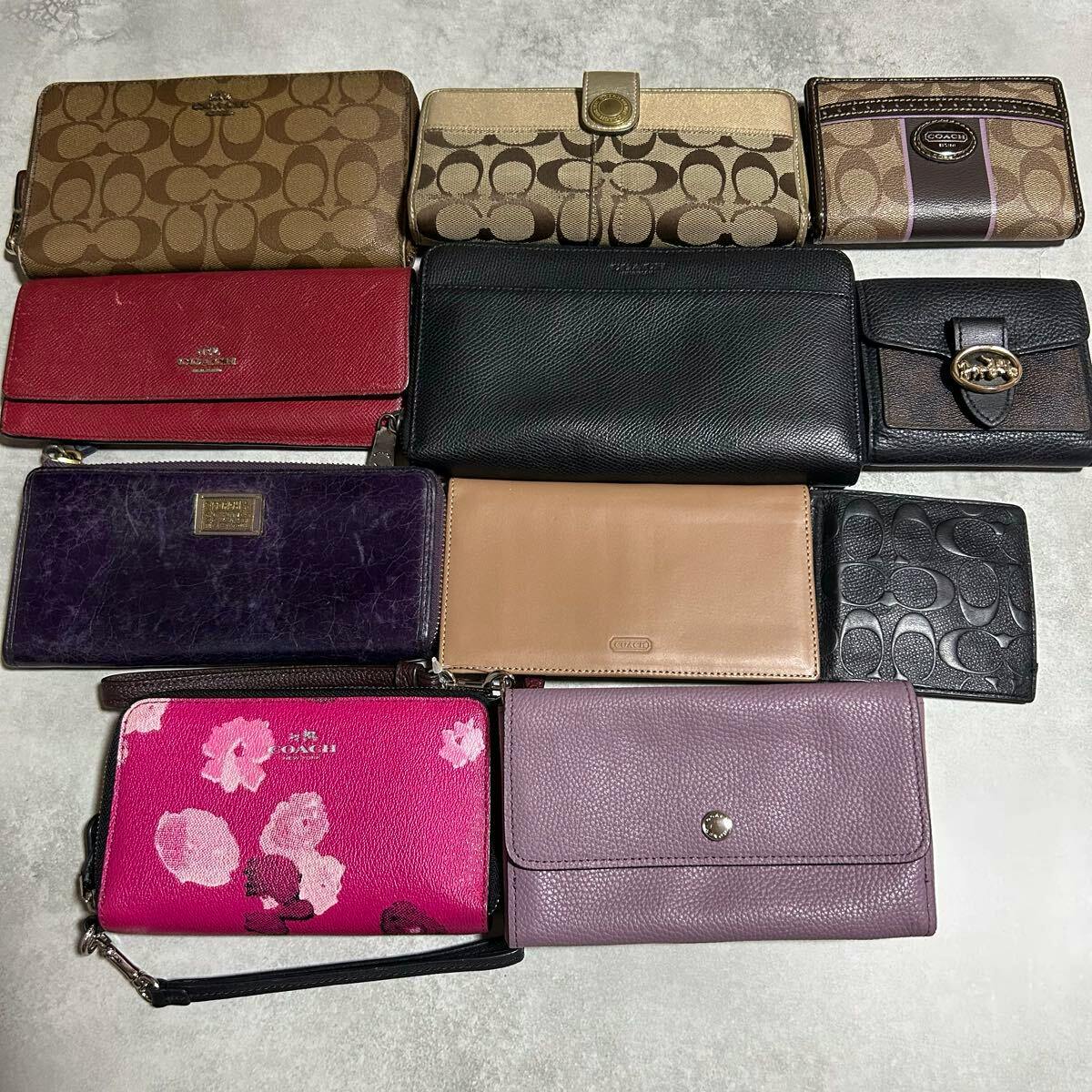 A set of eleven Coach wallets and small wallets in signature canvas and leather in assorted colors arranged flat on a light surface.